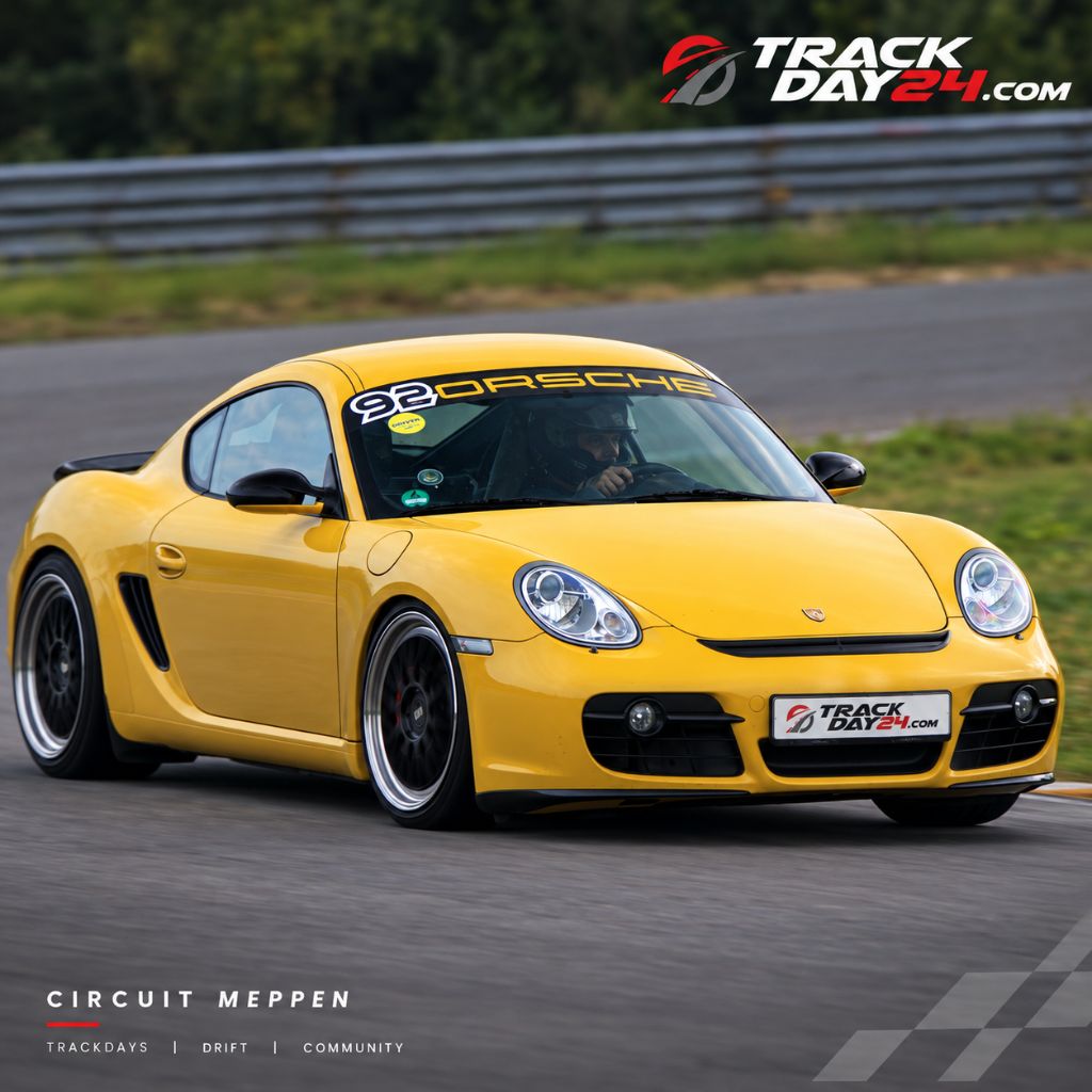 Gelber Porsche Cayman beim Trackday von TrackDay24 auf dem Circuit Meppen während einer schnellen Runde auf der Rennstrecke.