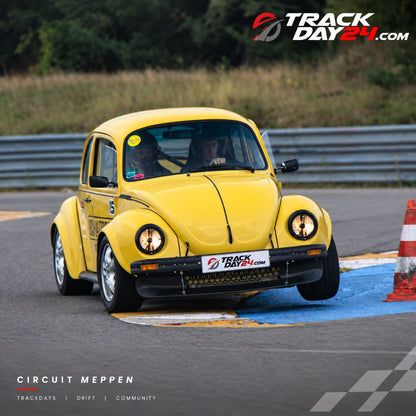 Gelber VW Käfer beim Trackday auf dem Circuit Meppen in einer Kurve. Motorsport und freies Fahren bei TrackDay24 in Meppen.