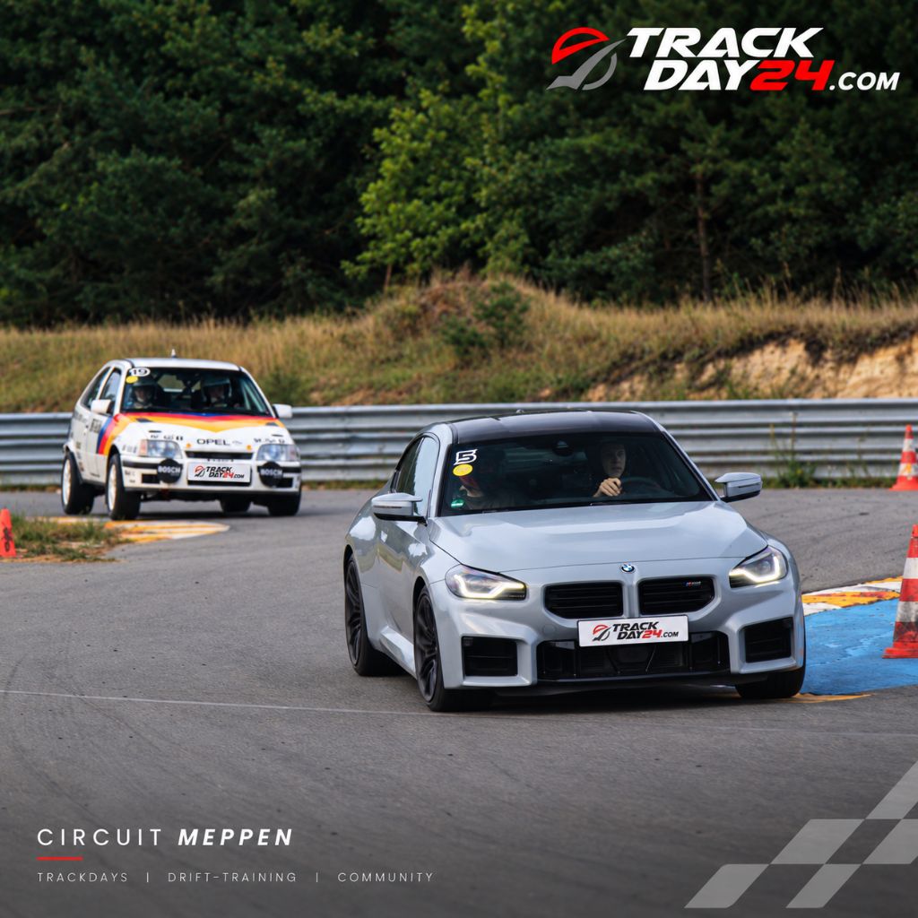 BMW M2 beim TrackDay24 Trackday auf dem Circuit Meppen, gefolgt von einem Opel Rennfahrzeug. Motorsport, Trackdays, Drift Training und Community bei TrackDay24.