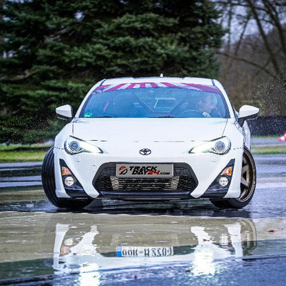 Toyota GT86 im Drift mit eingeschlagenen Vorderrädern auf Gleitbelag bei Trackday24, materialschonendes Drift Training mit viel Fahrspaß auf simuliertem Schnee